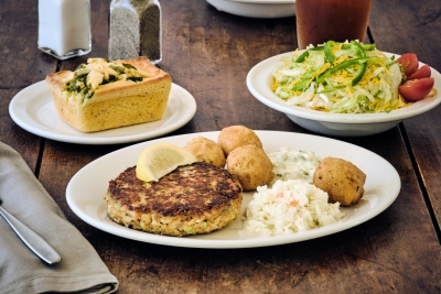 salmon pattie with hush puppies slaw and a salad